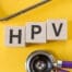 Napis HPV poleg stetoskopa na rumenem ozadju